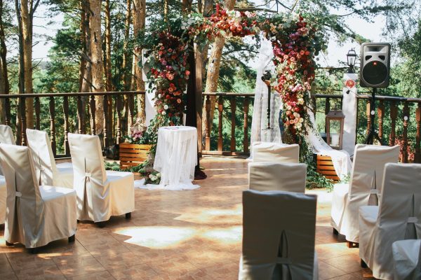 white-chairs-stand-before-wedding-altar-porch-min